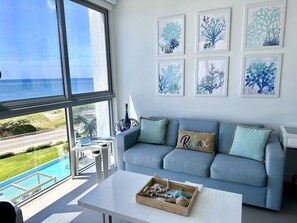 living room with pool view and ocean