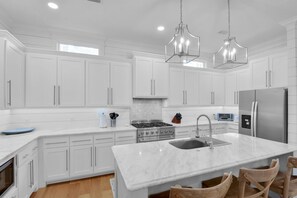 Chef’s Kitchen at Blue Heron Cottage – Gas Range & Large Island - This kitchen’s got range—literally. Stainless steel appliances, a deep sink, and a huge island with seating make it easy to cook, snack, or hang out in the heart of the home. Bonus points for the gas stove and clean coastal style.