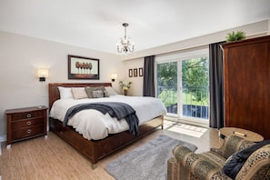 King-size master bedroom with oversized bedding. Enjoy the view over the pool from the sliding door balcony.