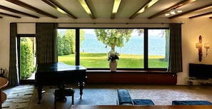 Blick auf das Wohnzimmer mit Flügel, Panoramafenster und Heimkino.