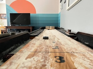 Try your hand at shuffle board. We also have a bowling modification for the table with wood pins and a ball. Super fun for game night at the Airbnb. 