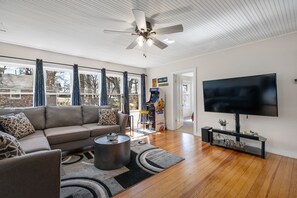 Spacious living room with 65 inch roku tv and pac man arcade