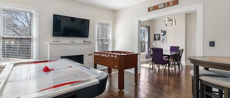 Game room featuring full size air hockey, fooseball, game table and 55 inch roku