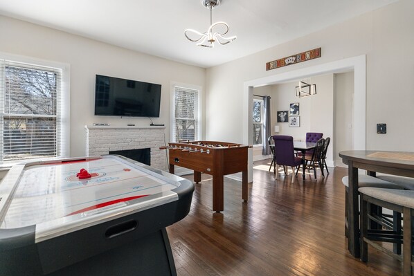 Game room featuring full size air hockey, fooseball, game table and 55 inch roku