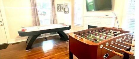 game room featuring air hockey, foosball, game board table, 55 inch roku tv 