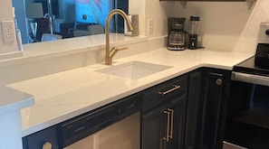 Brand new kitchen . Kohler faucet, new granite countertops and navy cabinets.