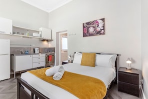 This comfortable bed with a well-equipped kitchenette, perfect for a cozy stay.