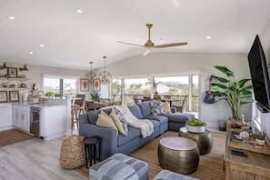 As you step into Seashell Escape, you are greeted by a sunlit open-concept living space, adorned with stylish furnishings that effortlessly merge comfort and elegance.