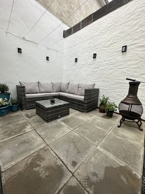 Private back garden courtyard, with corner sofa and coffee table. 