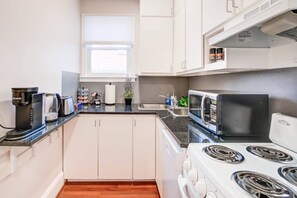 Create culinary delights in this cozy, fully equipped kitchen, nestled within a Heart of Old Town Alexandria apartment just steps from local food markets and dining treasures.