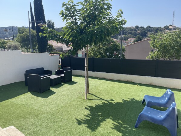 2 grandes terrasses avec une grande table manger et plancha