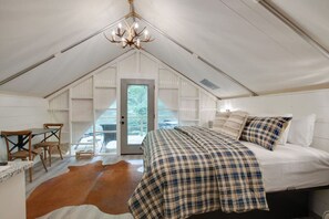 Bright and cozy glamping tent with modern, tasteful decor, a plush bed, and a comfy lounge area. Relax indoors or enjoy the outdoors with all the comforts you need for a perfect getaway.