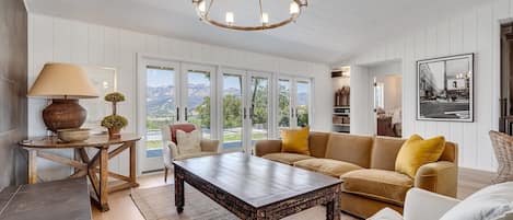 Living room with formal seating and views to the palisades and pool.