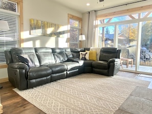 Family w/reclining sectional. Slider opens to deck. Blinds on all windows.