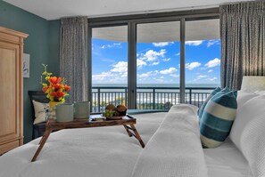 Sleep in Luxury: King-sized bed with new pillows and linens with a view of the ocean from the balcony. 
