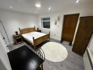 Main double bedroom. Work table. cupboard and wall hung ironing board with iron.