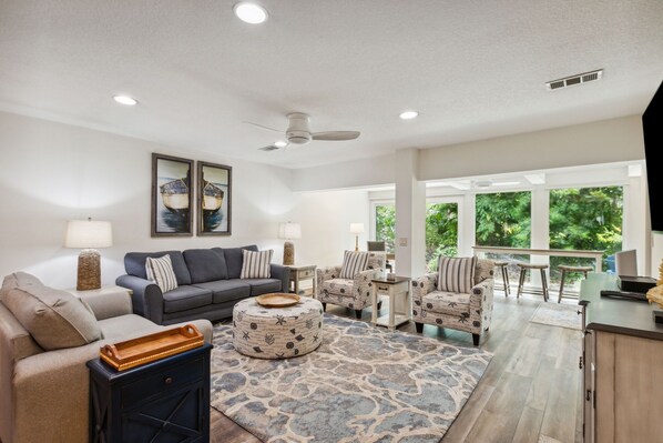 Bright and Cheerful Living Area with Two Sofas Centered Around a Flat Screen Smart TV