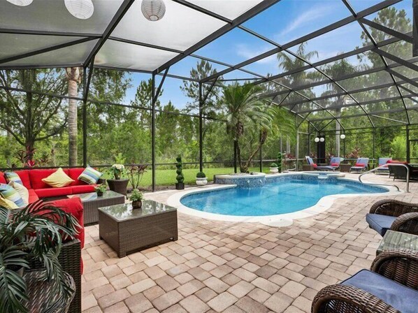 Relax in the screened-in pool area with scenic nature views and ample seating.