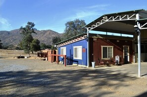 Parking area in front of the hitching post and blue wall. Peek at entrance 