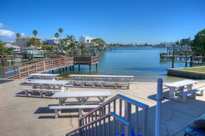 Outdoor shower, picnic tables and BBQ grill in shared community area.