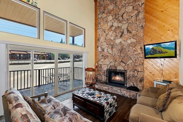 Living room with balcony views, fireplace, and cable TV