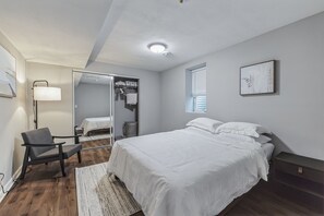 Large, bright room with a comfortable Queen-sized bed, accent chair for relaxing