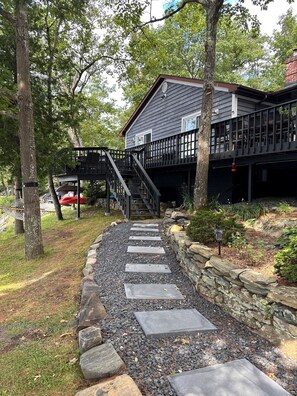 Pathway to deck overlooking the lake. Kayaks and paddle board stored under deck.