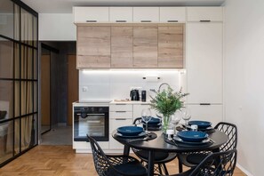 A dining area connected to a modern kitchen with light wooden cabinets.