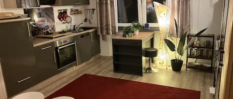 Wohnzimmer mit Küche, Schlafcouch und Smart TV
