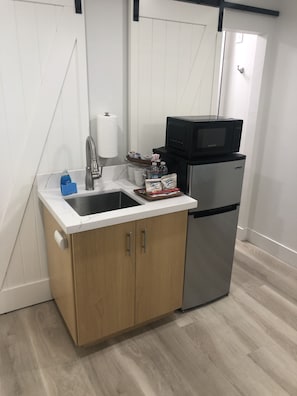 Kitchenette with sink, fridge/freezer and microwave.