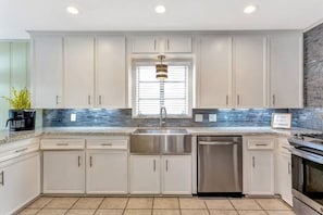 Beautifully decorated kitchen with all stainless steel appliances (stove, dishwasher, sink, and fridge) and under cabinet lighting!