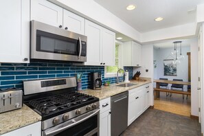 Kitchen with gas range, dishwasher, drip-style coffee maker, and pantry