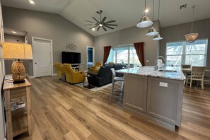 The home is elegantly yet comfortably furnished, inviting relaxation; large sliding glass doors lead to the balcony overlooking the outdoor space.