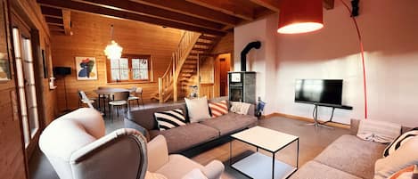 Gemütlicher Wohnbereich mit Ofen und TV / Cosy living area with fireplace and TV