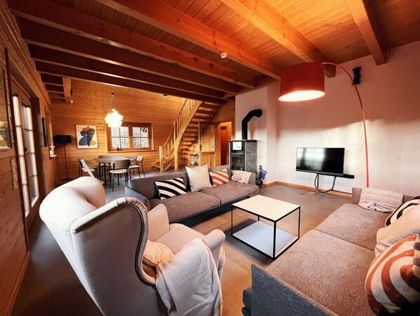 Gemütlicher Wohnbereich mit Ofen und TV / Cosy living area with fireplace and TV