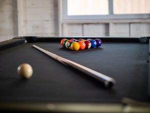 Game night ready! 🎯 This stylish garage hangout features a pool table, mounted TV, bar seating, string lights & a cozy vibe for hours of indoor fun. Perfect for rainy days or evening chill-outs! 🎱📺