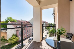 A spacious balcony with outdoor seating and a view of the surrounding urban landscape.