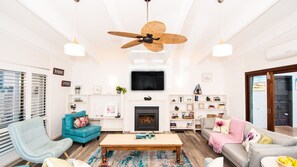 Lounge room featuring comfortable couches surrounding a cozy wood-burning fireplace.