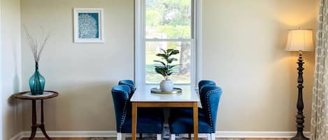 Combined living room dining room features large windows on two walls bathing the room in natural light.