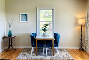 Combined living room dining room features large windows on two walls bathing the room in natural light.