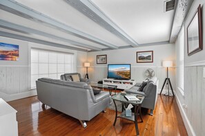 Living room which features a 65" ROKU enabled TV as well as BlueRay & Cable