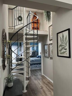 Spiral staircase to the loft bedrooms & view of main floor bedrooms