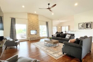 Open concept living room high ceilings, floor to ceiling fireplace huge windows 