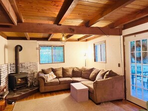 Cozy living room features couch fitting 6+ for a night around the wood stove