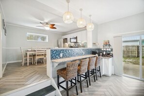 Dining table seats up to 6 guests with six bar stools surrounding the bar.