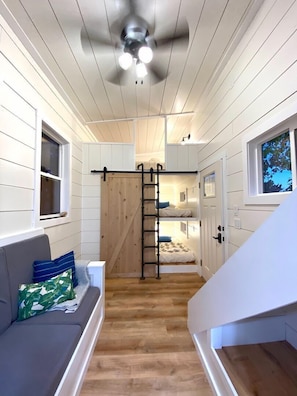 The living area makes this roomy "tiny" home feel open and spacious with the high ceilings and windows.