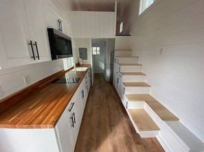 Kitchen oasis—features a compact stove, mini fridge, and wooden countertop.