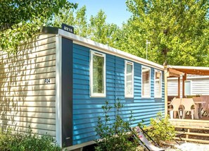 Charming mobile home with a vibrant blue exterior, perfect for a peaceful getaway.