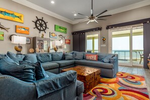 Vibrant and spacious living room with ocean views, comfy sectional, and coastal decor in Dauphin Island, Alabama.