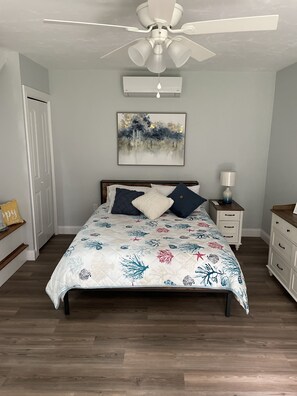 Bedroom with queen size bed, dresser, bench to sit and relax or watch a movie.